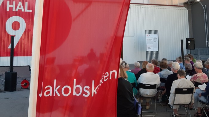 En stor rød banner med et hvidt kors og teksten