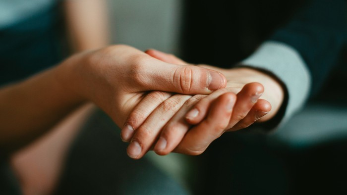 To hands holder hverandre trøstende