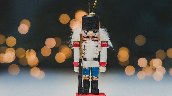 Ein Weihnachtsbaumschmuck in Form eines Nussknackers mit Uniform und Federkopfbedeckung.