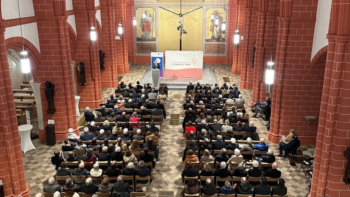 Große Kirche mit vielen Menschen in Reihen sitzend