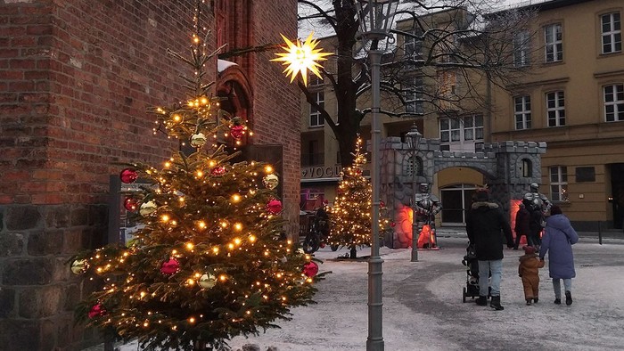 Weihnachtsbäume in der Stadt, Menschen schlendern umher