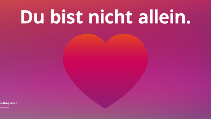 Das Bild zeigt einen roten Herz auf einem lila Hintergrund mit dem Text "Du bist nicht allein."