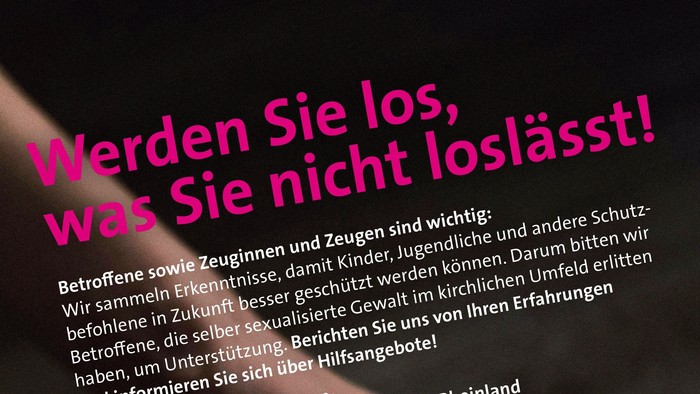 Die Hand hält eine weiße Karte mit Text, auf der ein Stopp-Symbol und eine Telefonnummer zu sehen sind.