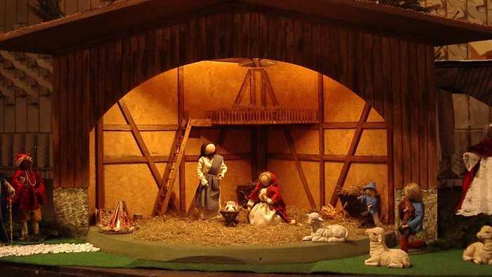 Eine Weihnachtskrippe mit Figuren und beleuchtetem Stall