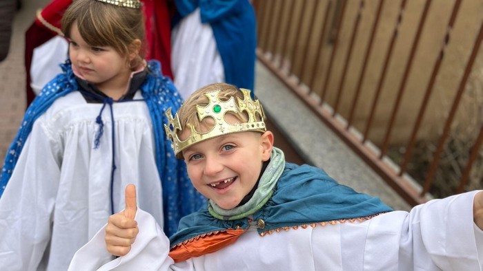 Zwei Kinder in Königskostümen, eines mit Krone und Daumen hoch.