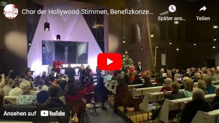 Ein Benefizkonzert des Hollywood-Stimmen-Chors mit Publikum in einem festlich geschmückten Saal.