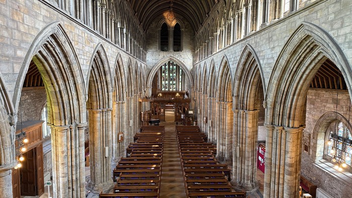 Large, empty cathedral with wooden pews and high arched ceilings