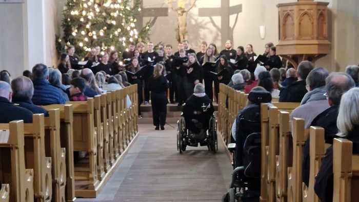 Kirchliche Weihnachtsfeier mit vielen Menschen und Christbaum