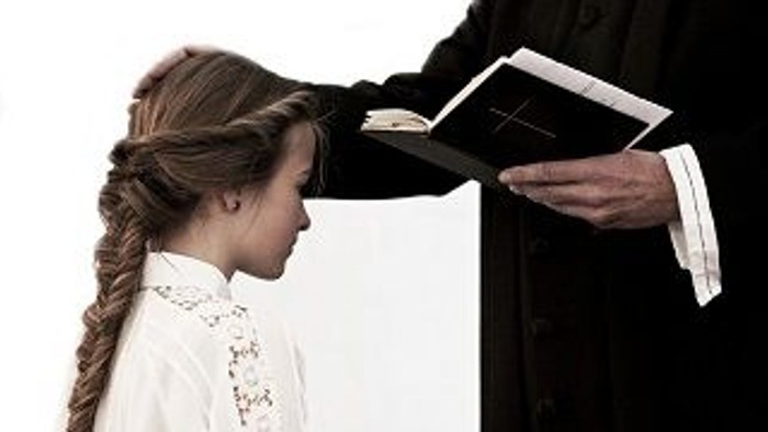 En ung pige modtager en bog fra en person i dommerdrægt.