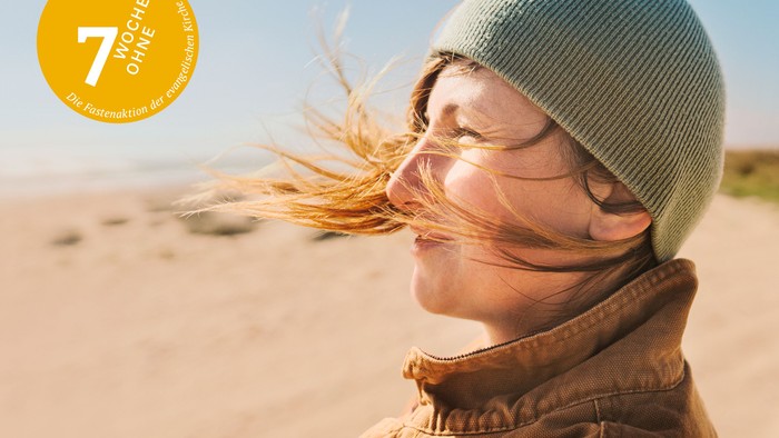 Frau am Strand mit Wind im Haar