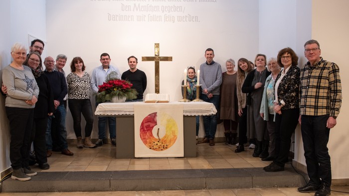 Eine Gruppe von Menschen steht vor einem Altar in einer Kirche