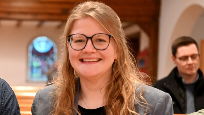 Ein Mann und eine Frau sitzen nebeneinander in einer Kirche.