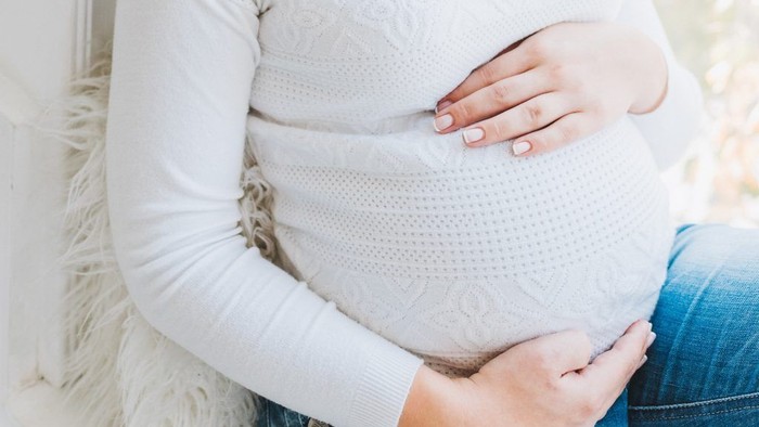 Schwangere Frau hält ihren Babybauch
