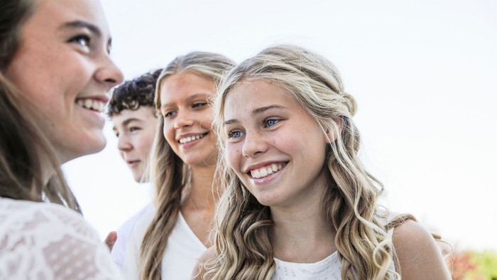 En gruppe unge kvinder smiler og ser glade ud.