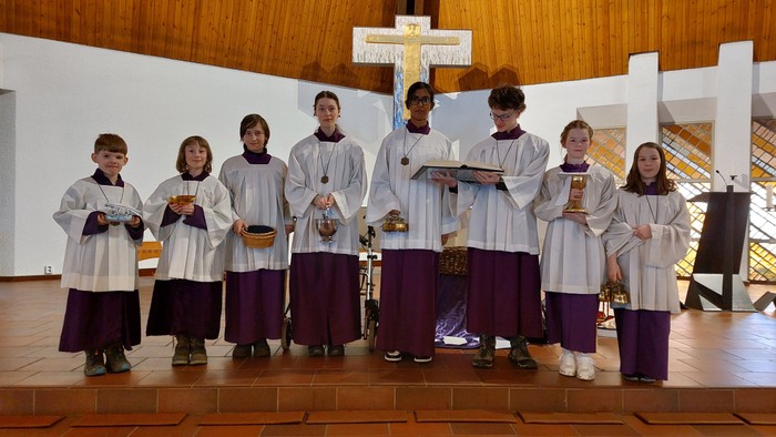 Eine Gruppe von Nonnen steht in einer Kirche vor einem Kreuz.