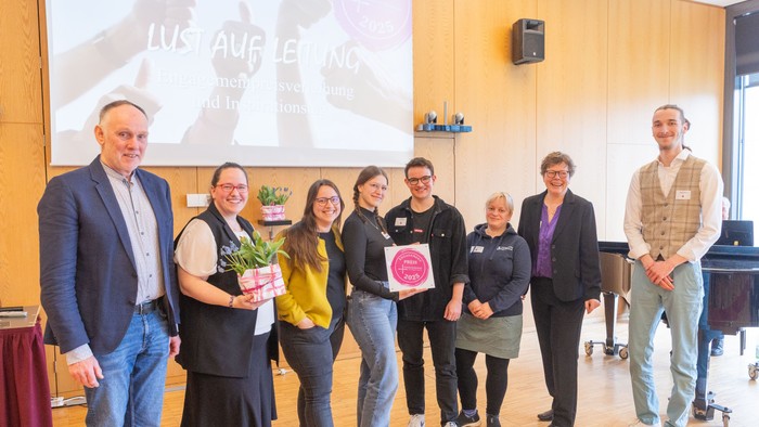 Jugendliche erhalten einen Engagementpreis, den sie im Rahmen des Jugend-Projektes der Evangelischen Kirche von Kurhessen-Waldeck gewonnen haben und lächeln in die Kamera