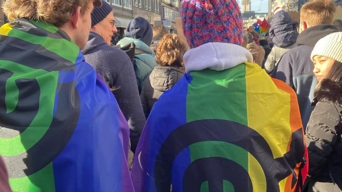 Menschen bei einer Demonstration mit bunten Schals und Fahnen
