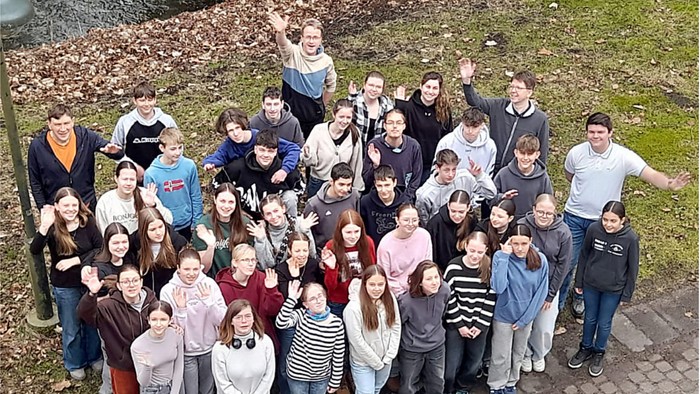 Eine große Gruppe von Menschen posiert für ein Gruppenfoto im Freien.