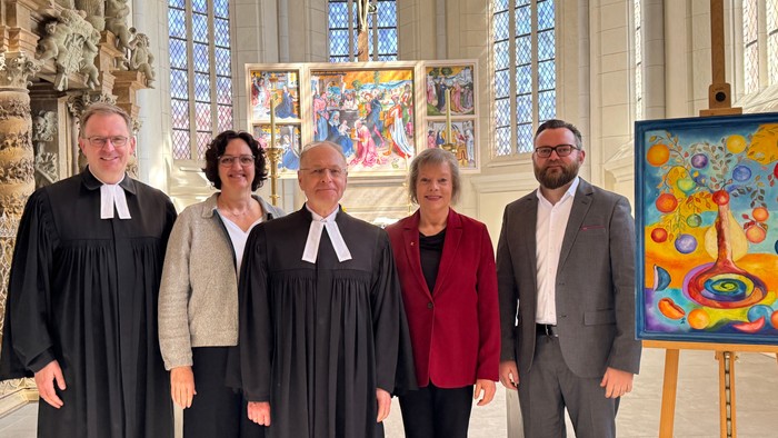 Gruppe von Personen, die vor religiöser Kunst posieren