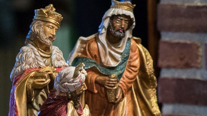 To statuer af konger med kroner og lange kapper, en holder en lille figur.