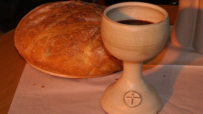 Ein Krug mit Wein und ein Brotlaib auf einem Tisch