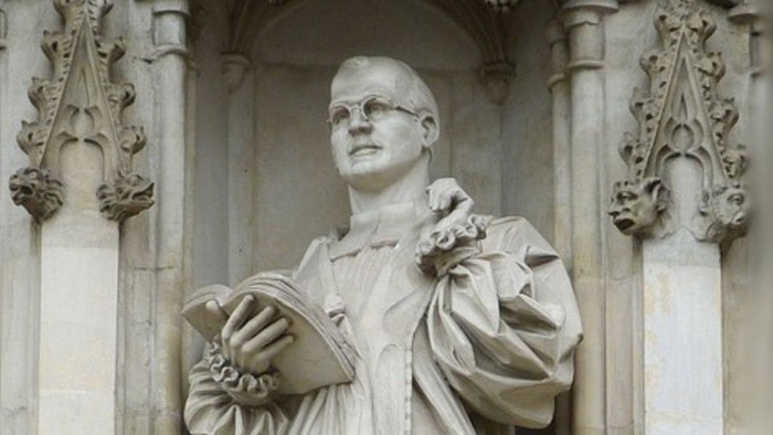 Die Statue eines Mannes mit Buch in einem historischen Gebäude.