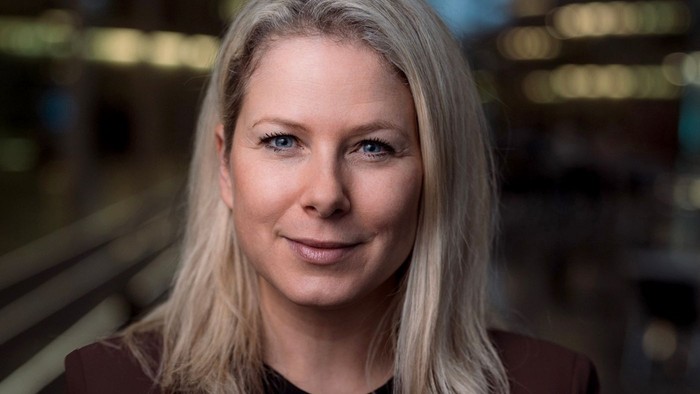 Eine Frau mit blondem Haar lächelt in die Kamera.