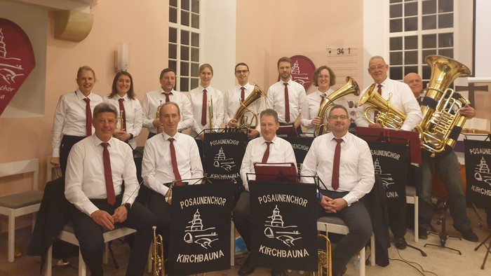 Eine Gruppe von Musikern, die mit ihren Blechblasinstrumenten posieren.