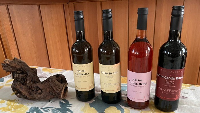 Vier Weinflaschen auf Tisch mit Holzdekoration