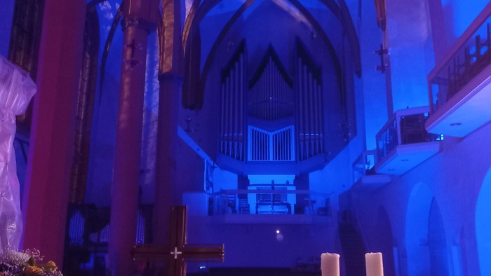 Kircheninneres mit Kreuz, Kerzen und Orgel