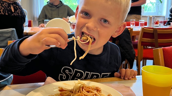 Børn spiser spaghetti i restaurant