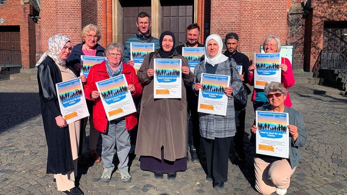 Eine Gruppe von Menschen hält Schilder mit der Aufschrift 