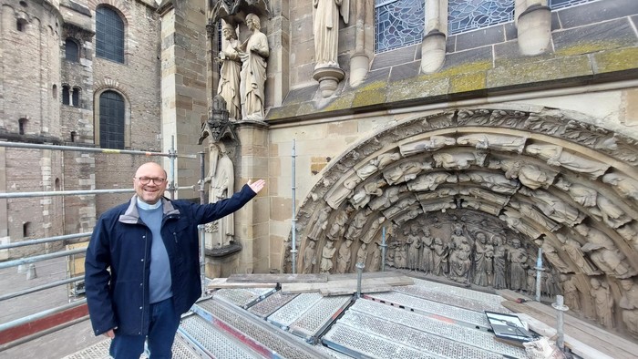 Mann vor historischem Gebäude mit Steinreliefs