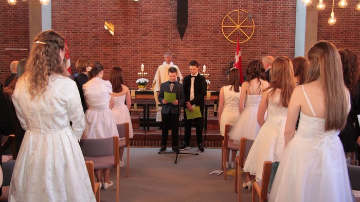 En gruppe mennesker i festlige kler i kirke.