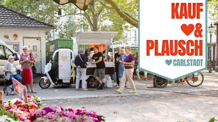 Ein lebendiger Marktplatz mit Menschen, die vor einem Food Truck mit dem Schild 