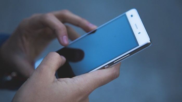 Person nutzt ein blaues Smartphone