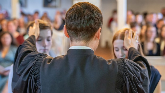 Absolventen in Kapuzenmänteln feiern bei Abschlusszeremonie