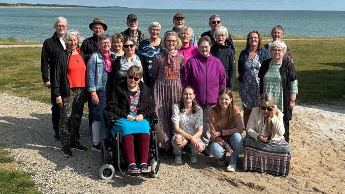 En gruppe af mennesker poser til et billede ved stranden