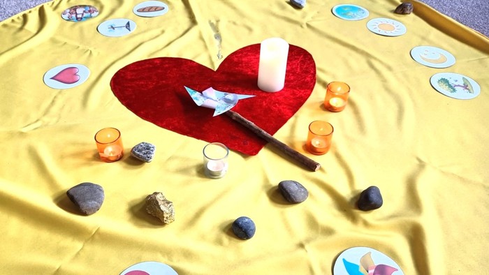 Rotes Herz mit Kerze und Steinen