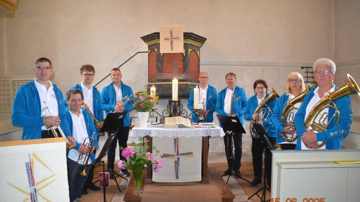 Kirchenband posiert mit Instrumenten vor dem Altar.