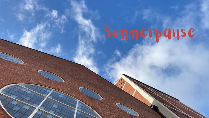 Blick an der Giebelwand der Martin-Luther-Kirche hoch in den blauen Himmel mit dem Schriftzug