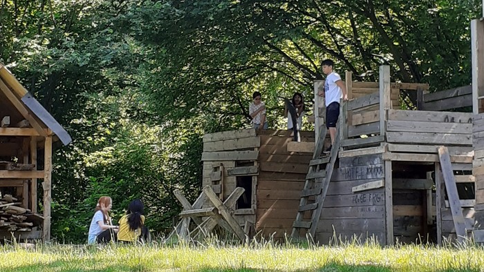 Kinder spielen auf einem Holzspielplatz im Freien
