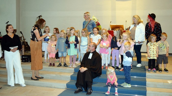 Viele Kinder des Matthäus-Kindergartens sangen Andreas Finke, der auf denn Altarstufen sitzt, Lieder zum Abschied.