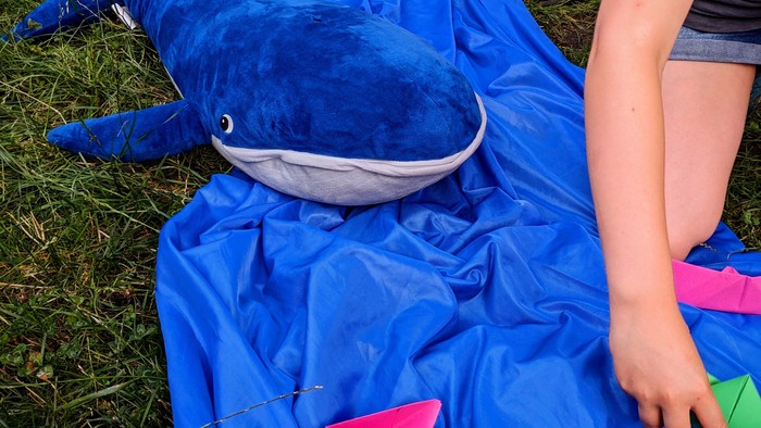 Wal mit Booten vor blauem hintergrund