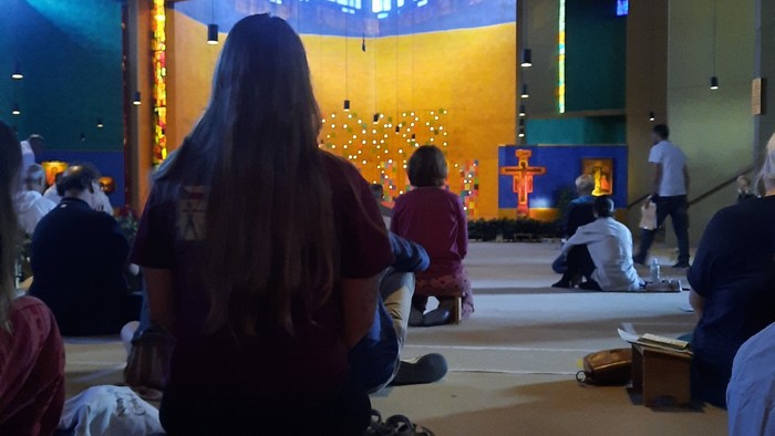 Jugendliche sitzen in der Kirche von Taize