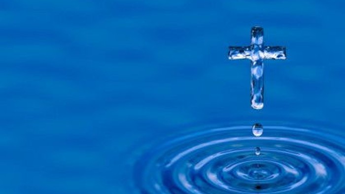 Ein Kreuz schwebt über Wasser mit kreisförmigen Wellen.