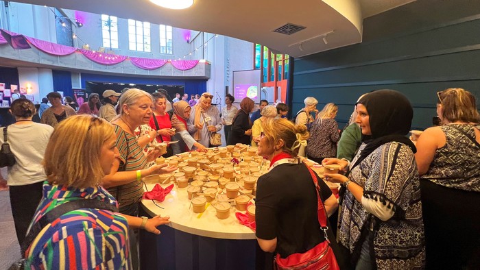 Eine große Gruppe Frauen feiert im Innenraum der Genezarethkirche.