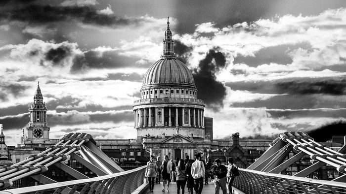 Schwarze und weiße Fotografie des St. Paul's Cathedrals in London mit Menschen auf der Millennium Bridge.