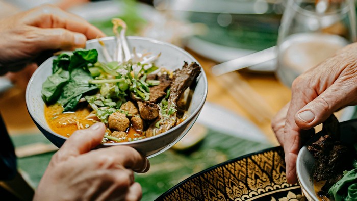 Mehrere Menschen teilen indisches Curry