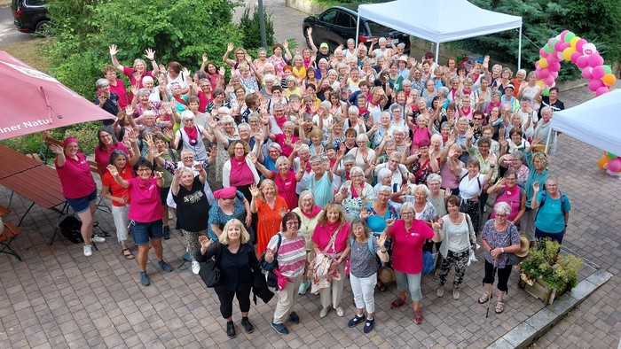 Große Gruppe von Menschen feiert bei Event im Freien